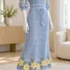 Powder blue crochet lace midi skirt and top set with pale yellow flower appliques and green leaves on mannequin
