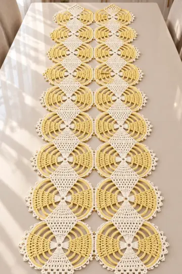 Butter yellow and ivory crocheted lace table runner with circular medallions and filet diamond appliques on white table