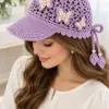 Lavender crocheted ponytail cap with mesh crown, scalloped edge, and ivory butterfly appliques worn by woman